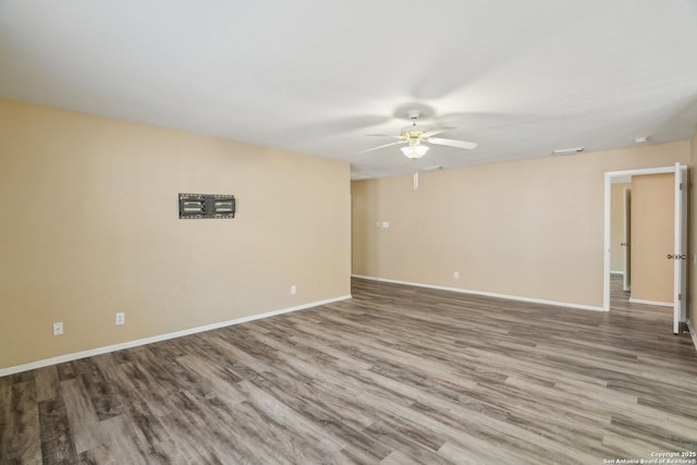 unfurnished room featuring baseboards, wood finished floors, and ceiling fan