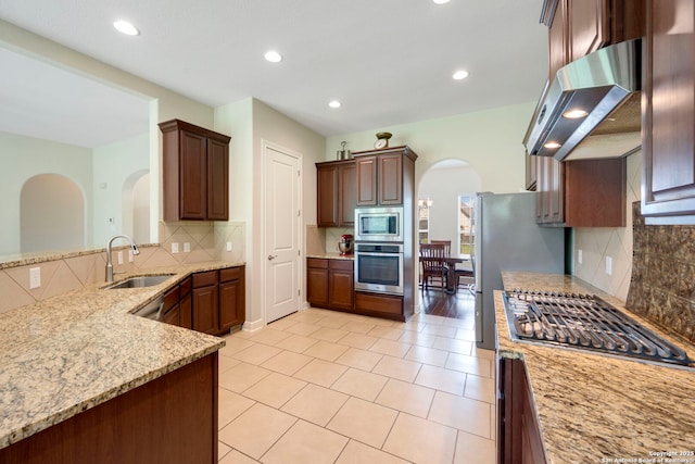 146 Sunrise Hl, Castroville, TX 78009 - kitchen with a sink, stainless steel appliances, range hood, arched walkways, and backsplash