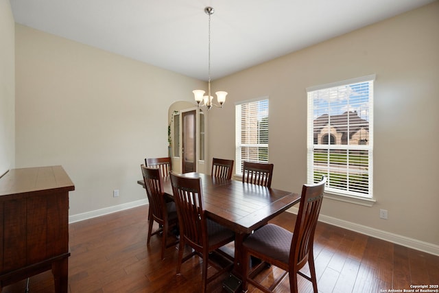 146 Sunrise Hl, Castroville, TX 78009 - dining area featuring baseboards, dark wood-style flooring, an inviting chandelier, and arched walkways