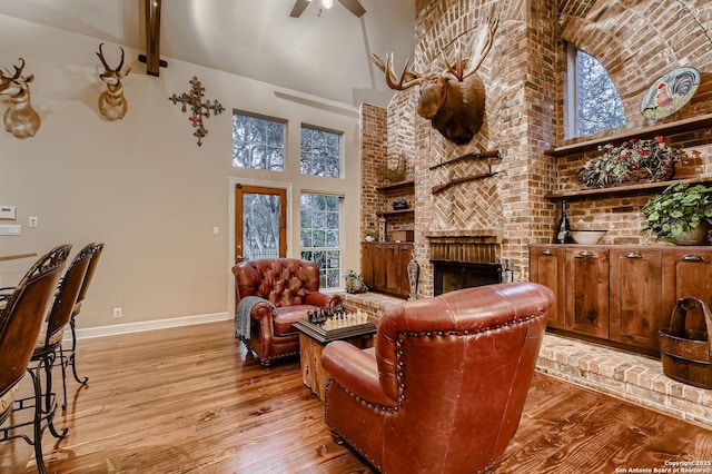 409 Sandy Oaks, Boerne, TX 78015 - living room with baseboards, a towering ceiling, ceiling fan, a fireplace, and wood finished floors