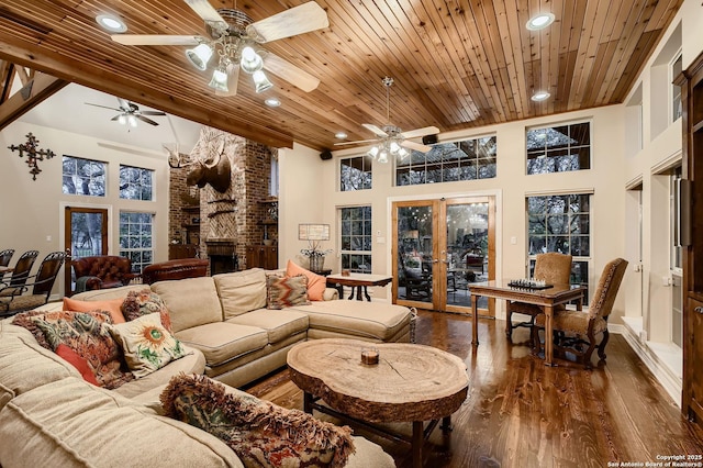 409 Sandy Oaks, Boerne, TX 78015 - living room featuring a brick fireplace, wood ceiling, a towering ceiling, dark wood-style floors, and a ceiling fan