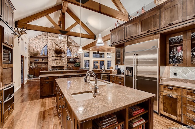 409 Sandy Oaks, Boerne, TX 78015 - kitchen with stainless steel built in refrigerator, light wood finished floors, a kitchen island with sink, a sink, and open floor plan