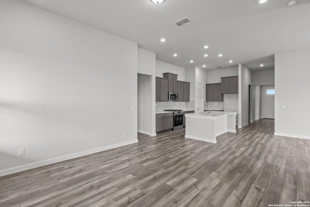 1509 Passmore Downs, New Braunfels, TX 78130 - unfurnished living room featuring light wood finished floors, baseboards, recessed lighting, and a sink