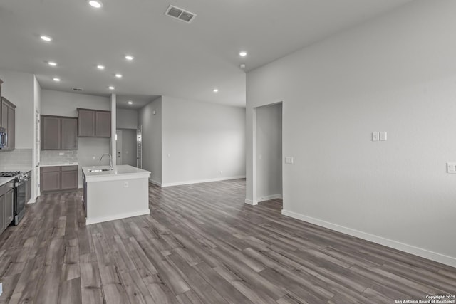 1509 Passmore Downs, New Braunfels, TX 78130 - kitchen with stainless steel appliances, a sink, an island with sink, open floor plan, and dark wood finished floors