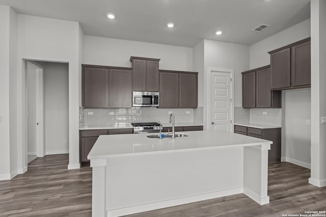1509 Passmore Downs, New Braunfels, TX 78130 - kitchen featuring appliances with stainless steel finishes, a sink, an island with sink, wood finished floors, and recessed lighting