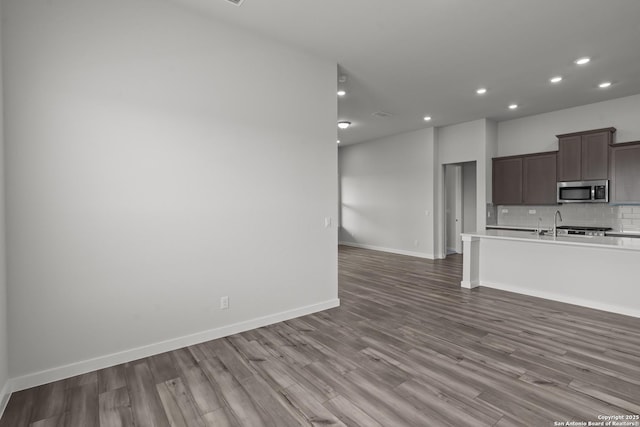 1509 Passmore Downs, New Braunfels, TX 78130 - kitchen featuring stainless steel microwave, wood finished floors, recessed lighting, backsplash, and light countertops