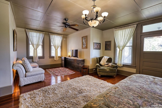 bedroom featuring baseboards, wood finished floors, a notable chandelier, and ornamental molding