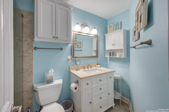 full bath featuring toilet, vanity, and baseboards