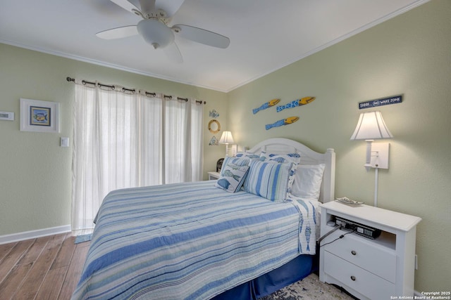 bedroom featuring baseboards, wood finished floors, ceiling fan, and ornamental molding