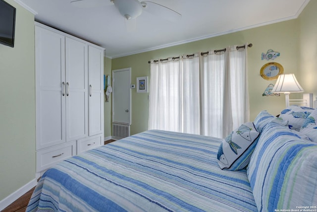 bedroom featuring dark wood-type flooring, baseboards, ornamental molding, and a ceiling fan