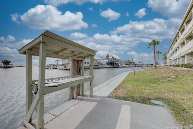 view of dock featuring a water view and a yard