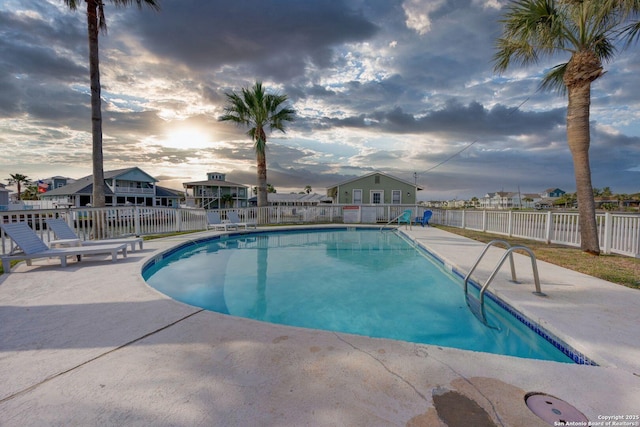 community pool with fence and a patio area