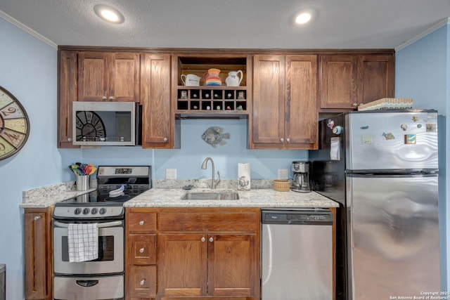 kitchen with ornamental molding, appliances with stainless steel finishes, a sink, open shelves, and light stone counters