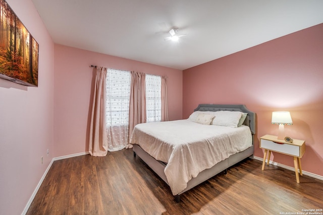 bedroom featuring baseboards and wood finished floors
