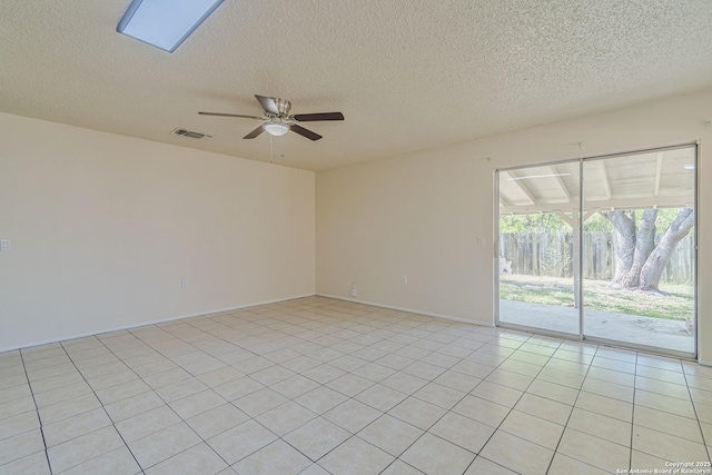 spare room featuring light tile patterned floors, a textured ceiling, ceiling fan, and visible vents