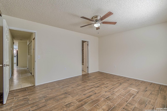 unfurnished room featuring a ceiling fan, a textured ceiling, baseboards, and wood finished floors