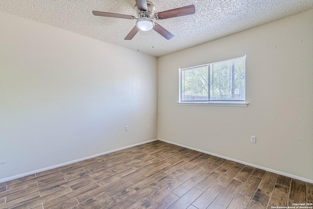unfurnished room with a textured ceiling, baseboards, and wood finished floors