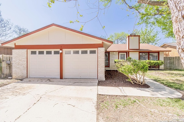 view of front facade featuring brick siding, driveway, a garage, and fence