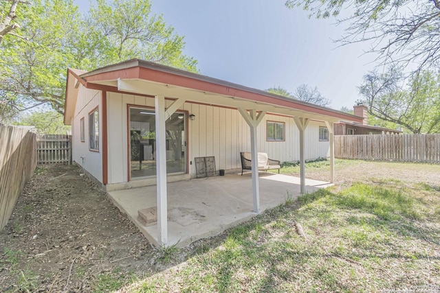rear view of property featuring a patio and a fenced backyard