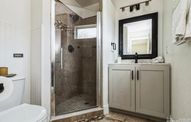 bathroom featuring a stall shower, toilet, and vanity