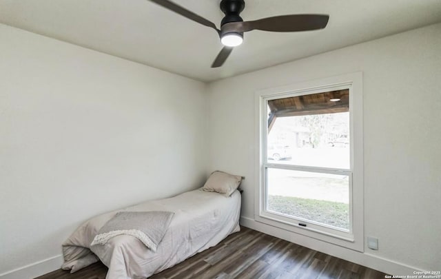 bedroom with baseboards, ceiling fan, and dark wood-style flooring