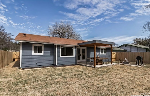 back of house featuring a fenced backyard, french doors, a yard, and a patio area