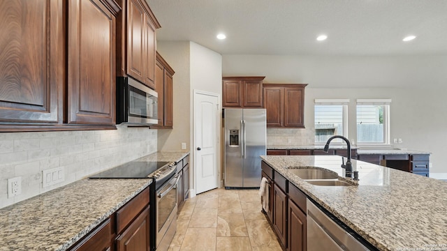 2144 Pioneer Pass, Seguin, TX 78155 - kitchen with appliances with stainless steel finishes, a sink, backsplash, light stone counters, and recessed lighting