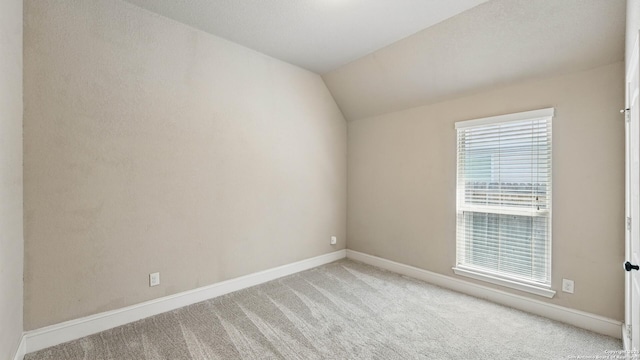 2144 Pioneer Pass, Seguin, TX 78155 - spare room featuring light carpet, vaulted ceiling, and baseboards