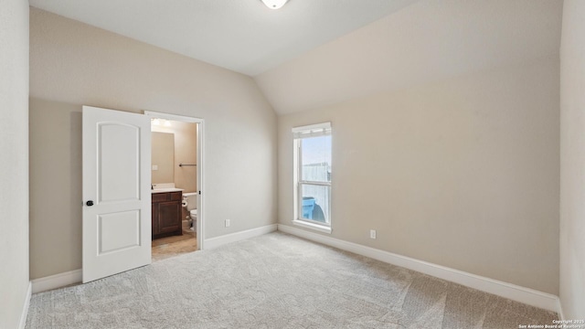 2144 Pioneer Pass, Seguin, TX 78155 - unfurnished bedroom with light carpet, lofted ceiling, baseboards, and ensuite bath
