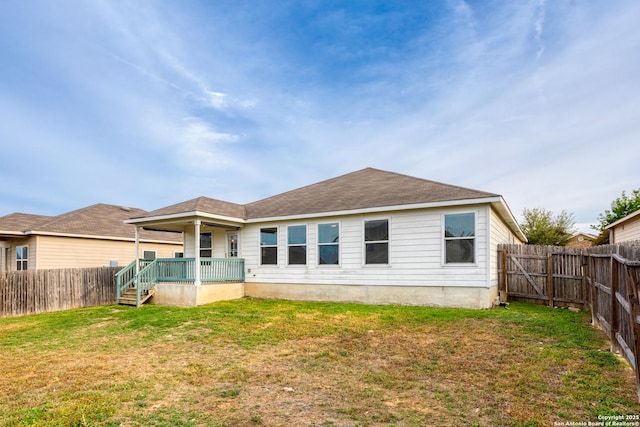 rear view of property featuring a lawn and a fenced backyard