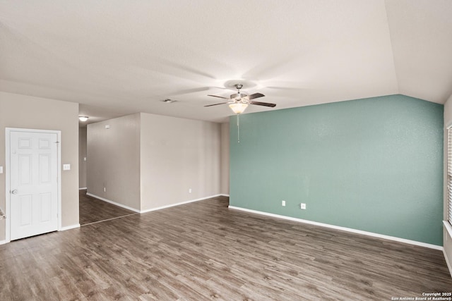 unfurnished room with vaulted ceiling, baseboards, visible vents, a ceiling fan, and wood finished floors