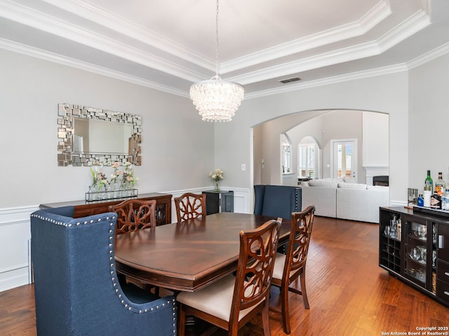 922 Split Fairway, San Antonio, TX 78260 - dining room featuring visible vents, a fireplace, wood finished floors, arched walkways, and an inviting chandelier