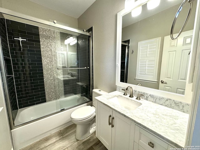 922 Split Fairway, San Antonio, TX 78260 - full bathroom with toilet, vanity, bath / shower combo with glass door, wood finish floors, and a textured wall