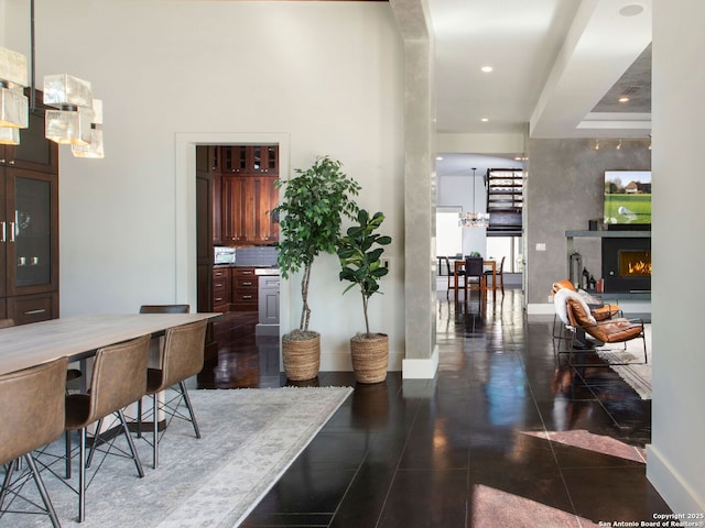 7110 Bella Rose, San Antonio, TX 78256 - interior space featuring a lit fireplace, tile patterned flooring, baseboards, recessed lighting, and an inviting chandelier