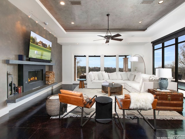 7110 Bella Rose, San Antonio, TX 78256 - living room featuring a warm lit fireplace, ceiling fan, a wealth of natural light, and a raised ceiling