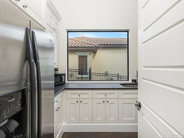 7110 Bella Rose, San Antonio, TX 78256 - kitchen with white cabinets, dark countertops, a sink, black microwave, and stainless steel refrigerator with ice dispenser