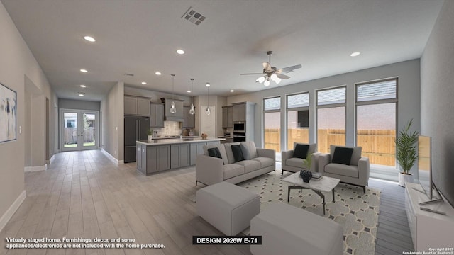 living area with plenty of natural light, light wood-style floors, ceiling fan, and visible vents