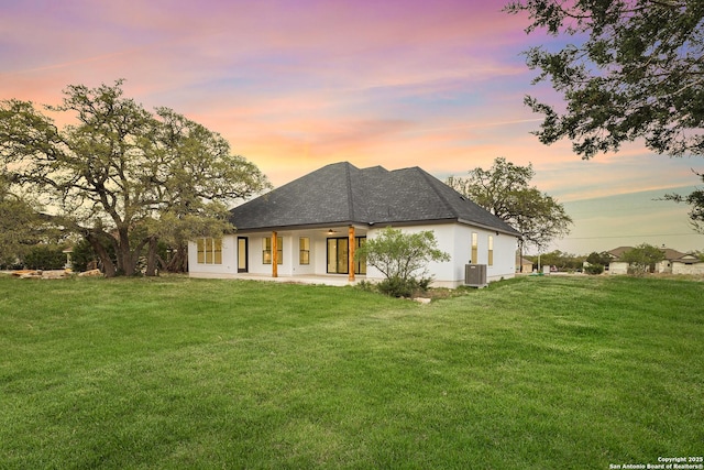 220 Toucan, Spring Branch, TX 78070 - back of house at dusk with a lawn, central air condition unit, a shingled roof, ceiling fan, and a patio area