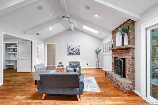 310 Twisted Wood, San Antonio, TX 78216 - living room featuring ceiling fan, a fireplace, light wood finished floors, and a skylight