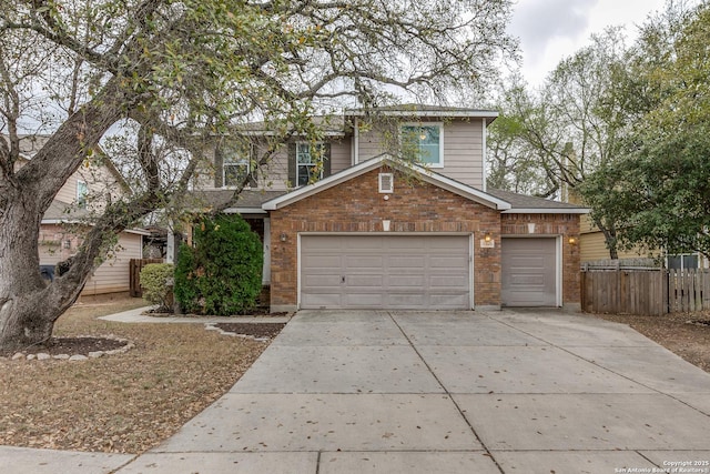 traditional-style home with concrete driveway, an attached garage, fence, brick siding, and a shingled roof