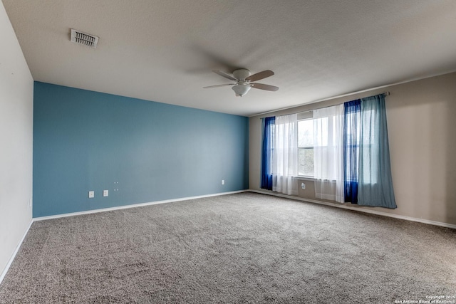 empty room with carpet flooring, a ceiling fan, baseboards, and a textured ceiling