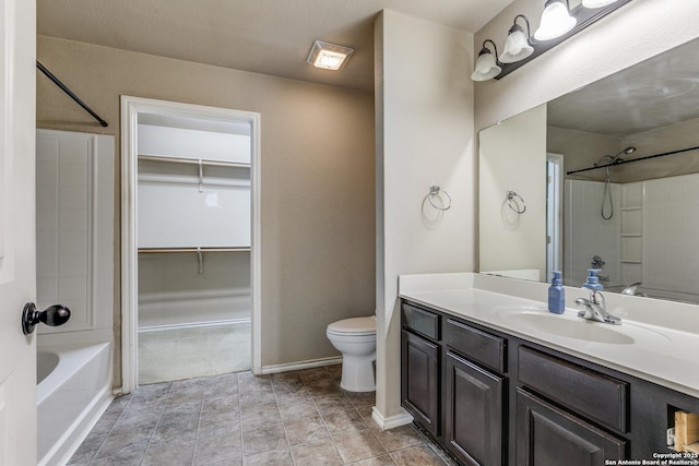 bathroom featuring toilet, vanity,  shower combination, a walk in closet, and tile patterned flooring