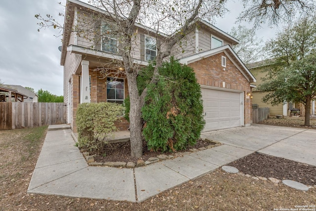 traditional-style home featuring brick siding, a garage, concrete driveway, and fence