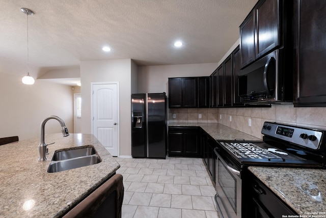 kitchen featuring light stone countertops, a sink, pendant lighting, black appliances, and backsplash