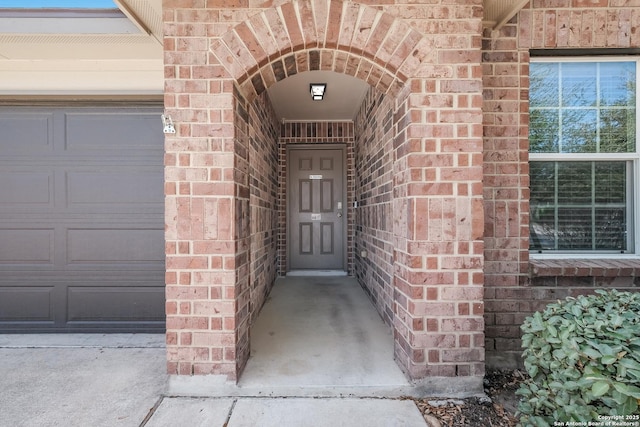 entrance to property featuring brick siding