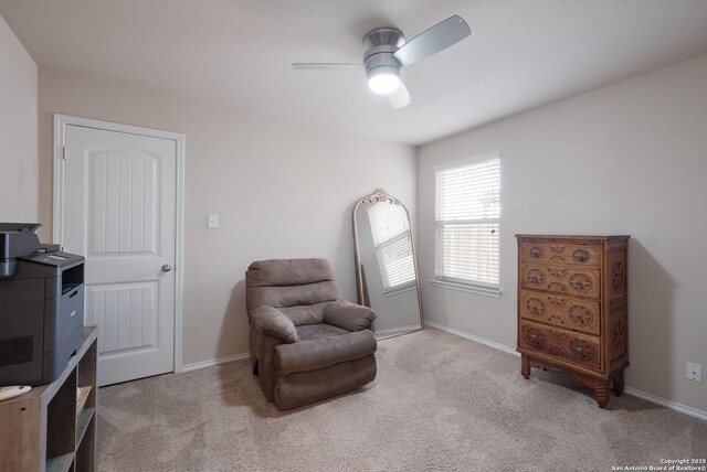 sitting room featuring light carpet, baseboards, and ceiling fan