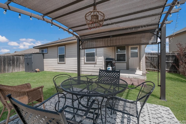 view of patio / terrace with an outdoor structure, a fenced backyard, outdoor dining space, and area for grilling