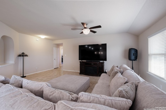 living room featuring baseboards, lofted ceiling, and a ceiling fan