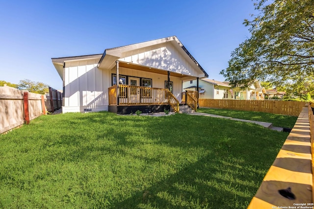 back of property with a yard, a porch, board and batten siding, and fence private yard
