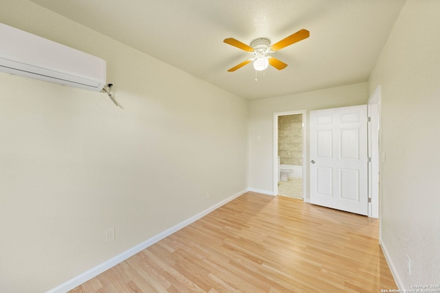 empty room with light wood-style floors, ceiling fan, baseboards, and an AC wall unit